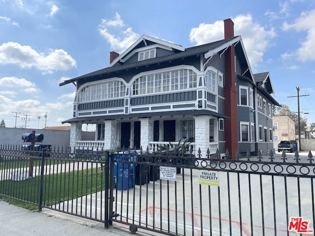 view of front of house featuring a front lawn, covered porch, and a balcony