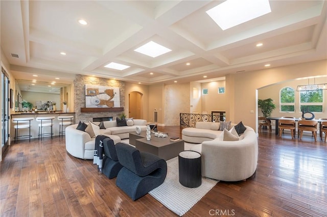 living room with beamed ceiling, a fireplace, dark wood-type flooring, and coffered ceiling