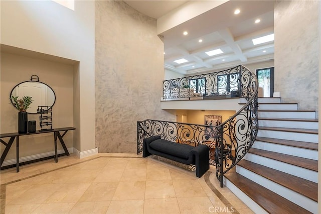 staircase featuring beamed ceiling, tile patterned flooring, a high ceiling, and coffered ceiling