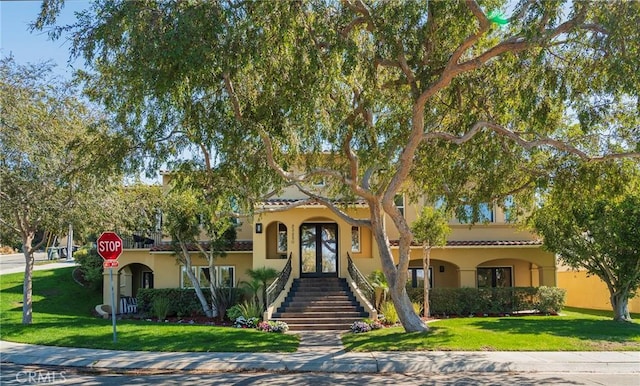 mediterranean / spanish home with a front yard