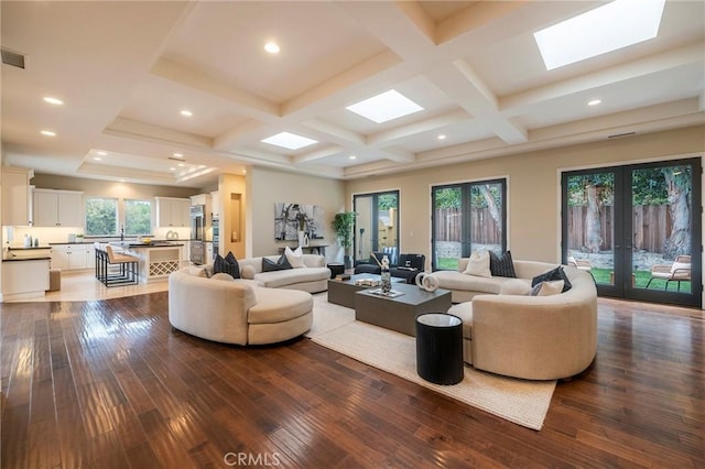 living room featuring beam ceiling, hardwood / wood-style floors, french doors, and coffered ceiling