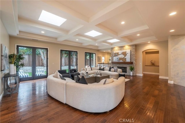 living room with a fireplace, french doors, dark hardwood / wood-style flooring, and beam ceiling