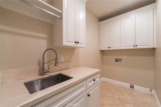 clothes washing area with sink, cabinets, and washer hookup