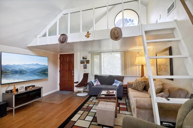 living room with wood-type flooring and high vaulted ceiling