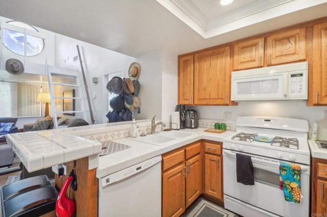 kitchen with tile counters, kitchen peninsula, ornamental molding, sink, and white appliances