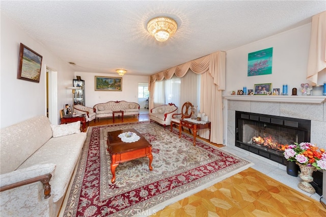 living room featuring a textured ceiling and a tile fireplace