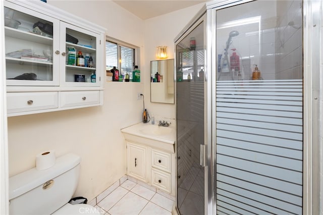 bathroom featuring vanity, an enclosed shower, toilet, and tile patterned flooring