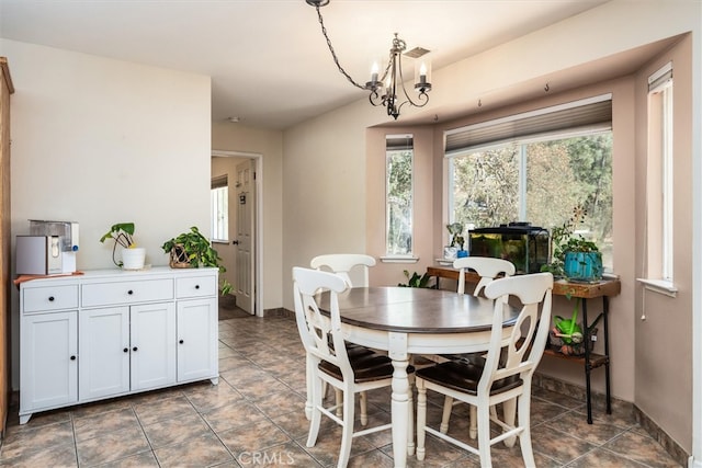 tiled dining area featuring a chandelier