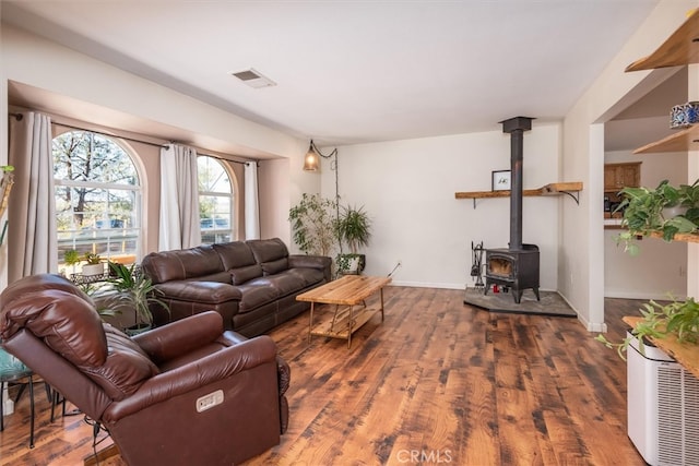 living room featuring dark wood-type flooring and a wood stove