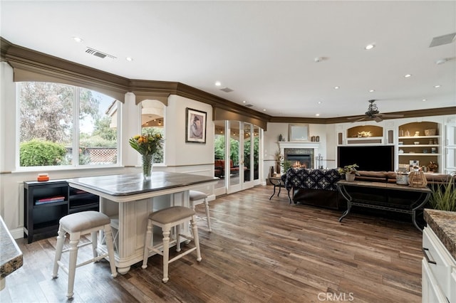 2550 E Jenny Ave, Fresno, CA 93720 - kitchen with ceiling fan, dark wood-type flooring, white cabinets, crown molding, and a kitchen island
