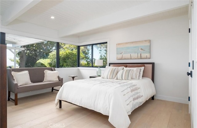 bedroom with beam ceiling and light wood-type flooring