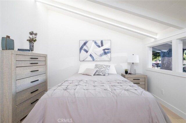 bedroom with vaulted ceiling with beams and hardwood / wood-style flooring