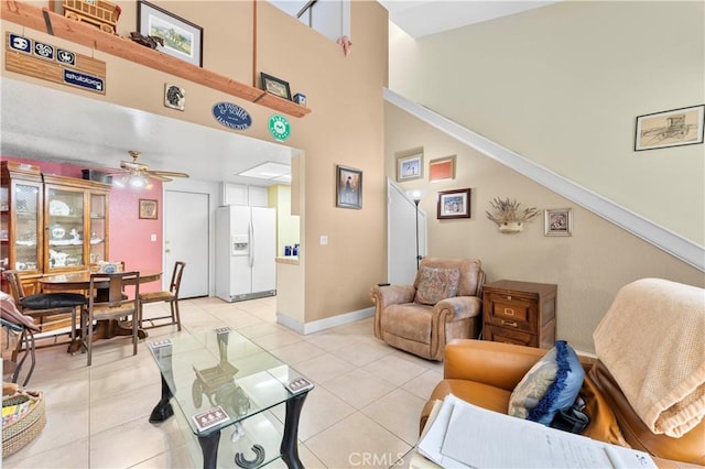 tiled living room with a towering ceiling and ceiling fan