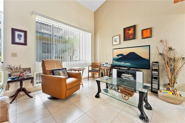 sitting room with light tile patterned floors and high vaulted ceiling