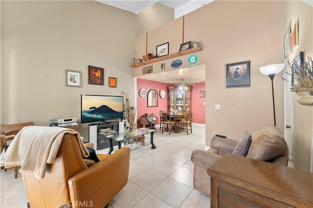 tiled living room featuring ceiling fan and a towering ceiling