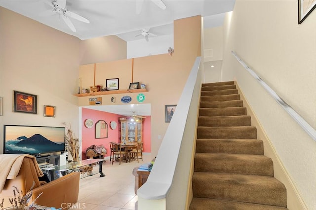 stairway featuring tile patterned flooring, a high ceiling, and ceiling fan