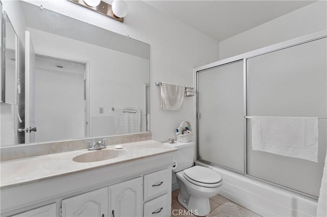 full bathroom with tile patterned flooring, vanity, toilet, and bath / shower combo with glass door