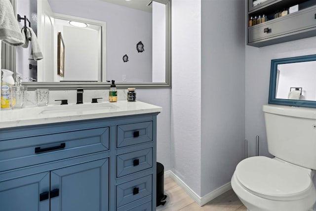 bathroom featuring toilet, vanity, and hardwood / wood-style flooring