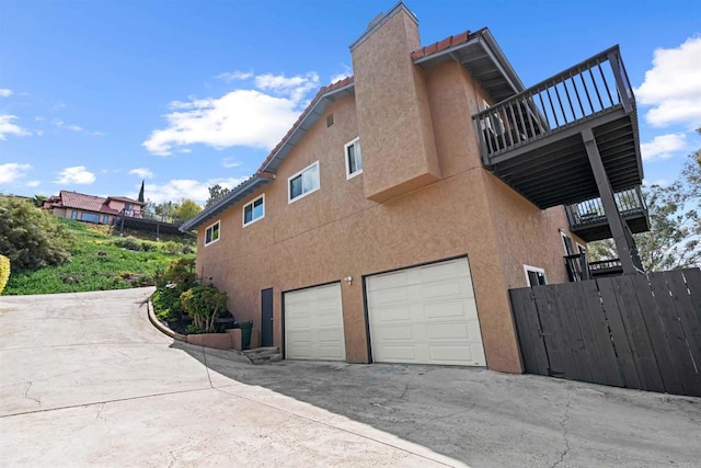 view of property exterior featuring a balcony and a garage