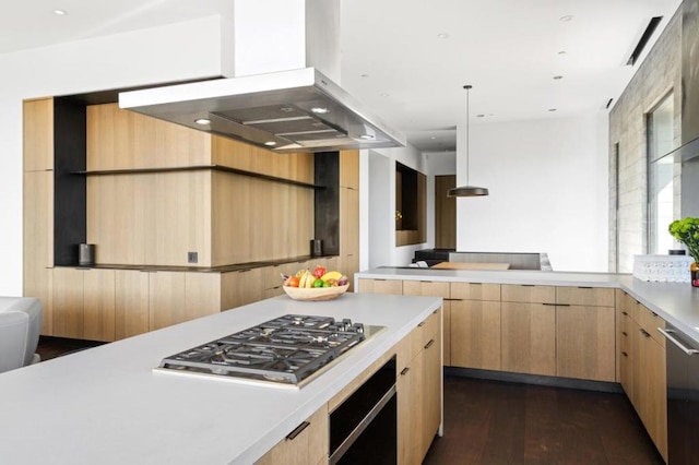 kitchen with light brown cabinetry, appliances with stainless steel finishes, decorative light fixtures, dark wood-type flooring, and island exhaust hood