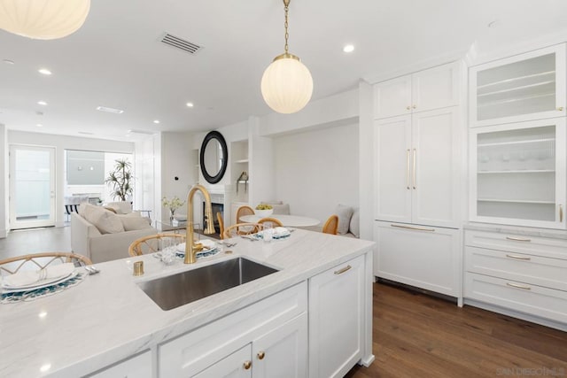 kitchen with dark hardwood / wood-style flooring, sink, white cabinets, and pendant lighting