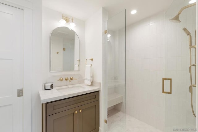 bathroom with a shower with door and vanity