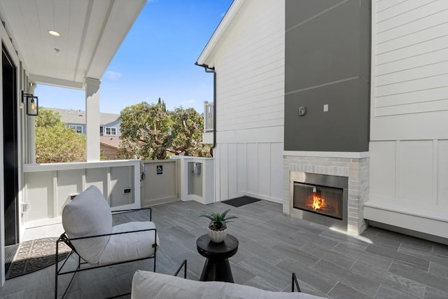 balcony featuring an outdoor brick fireplace