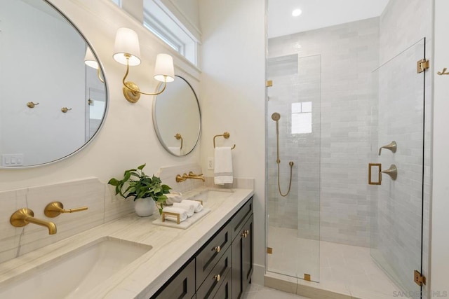 bathroom featuring a shower with door and vanity