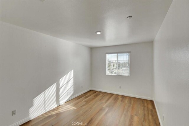 unfurnished room with light wood-type flooring