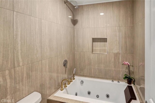 bathroom featuring toilet and tiled shower / bath