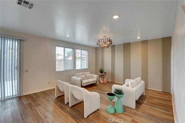 living room with a notable chandelier and light hardwood / wood-style floors