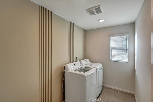 clothes washing area featuring light tile patterned floors and independent washer and dryer