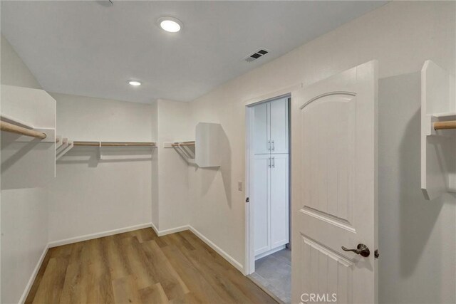 walk in closet with light wood-type flooring