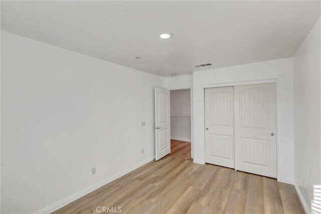 unfurnished bedroom featuring a closet and light hardwood / wood-style flooring