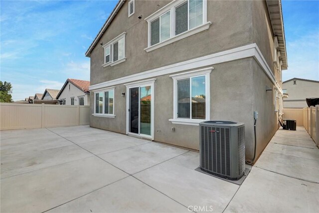 rear view of house with central AC unit and a patio area