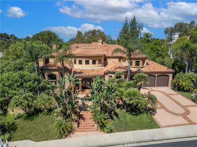 mediterranean / spanish-style house featuring a front lawn and a garage