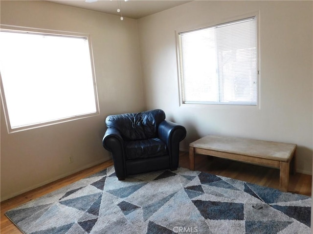 sitting room with ceiling fan and hardwood / wood-style flooring