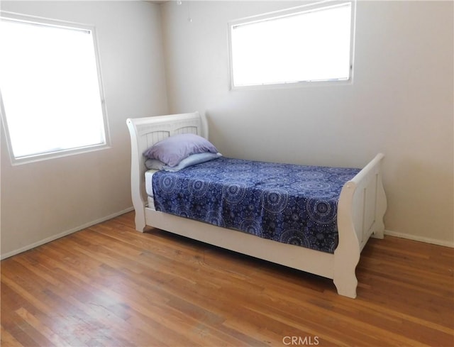 bedroom with hardwood / wood-style floors and multiple windows