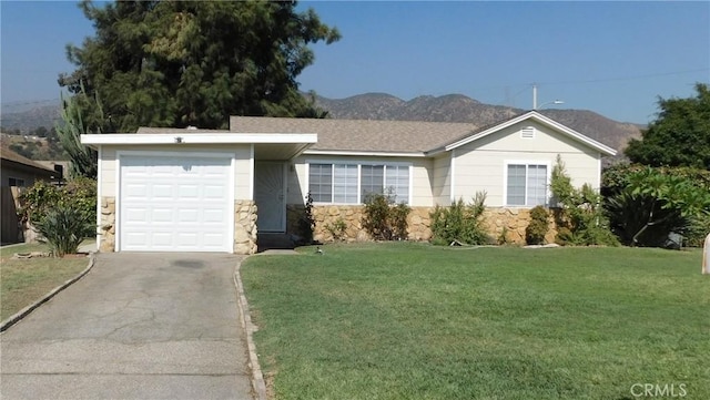 ranch-style house featuring a mountain view, a garage, and a front lawn