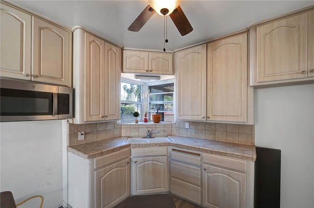 kitchen featuring tasteful backsplash, light brown cabinetry, tile counters, and sink