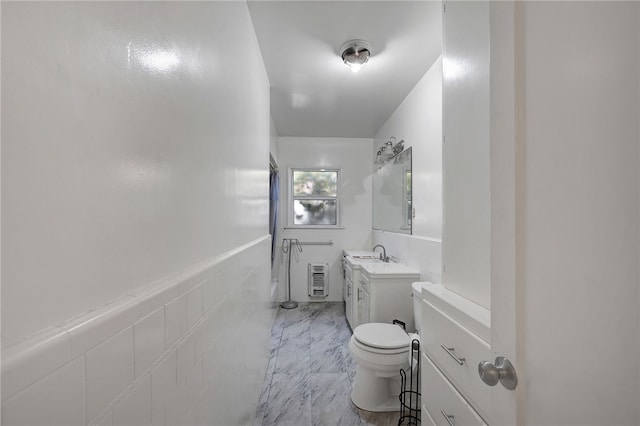 bathroom with vanity, tile walls, and toilet