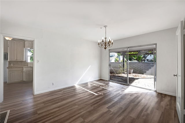 unfurnished dining area featuring dark hardwood / wood-style floors and a notable chandelier