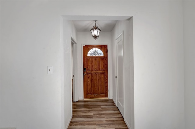 entryway with a notable chandelier and dark hardwood / wood-style flooring