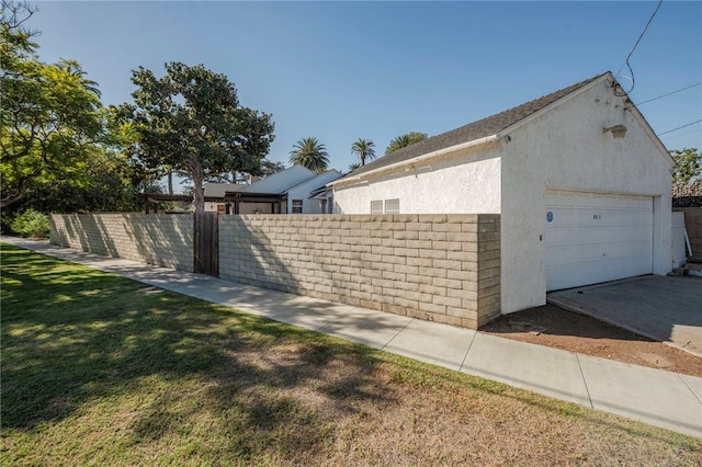 view of side of home featuring a lawn, an outdoor structure, and a garage