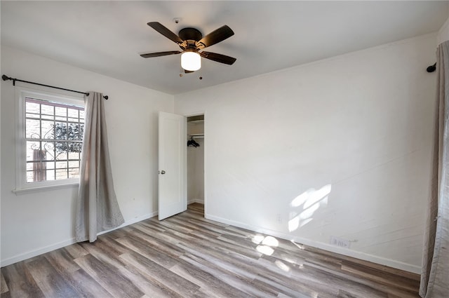 spare room with ceiling fan and light wood-type flooring