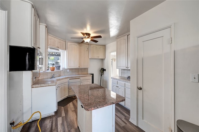 kitchen with decorative backsplash, dark hardwood / wood-style flooring, light stone counters, and ceiling fan