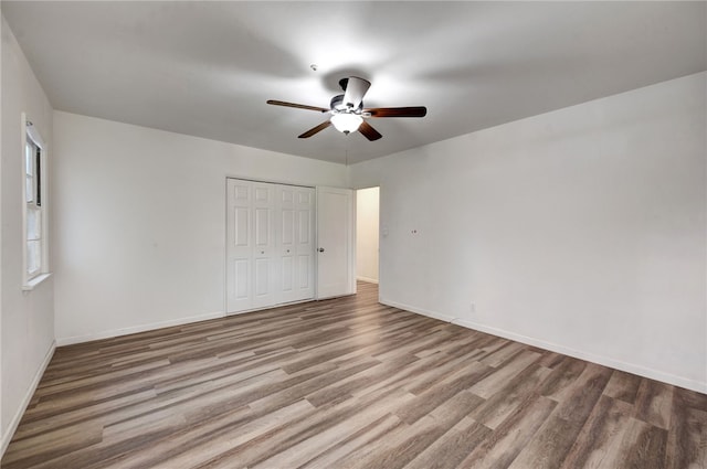 unfurnished bedroom featuring ceiling fan, light wood-type flooring, and a closet