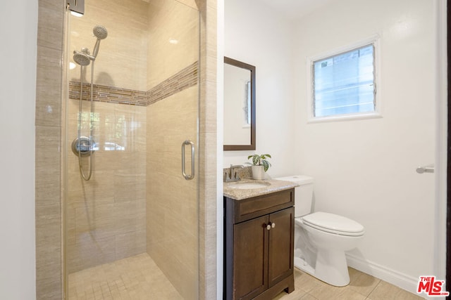 bathroom with tile patterned floors, vanity, a shower with shower door, and toilet