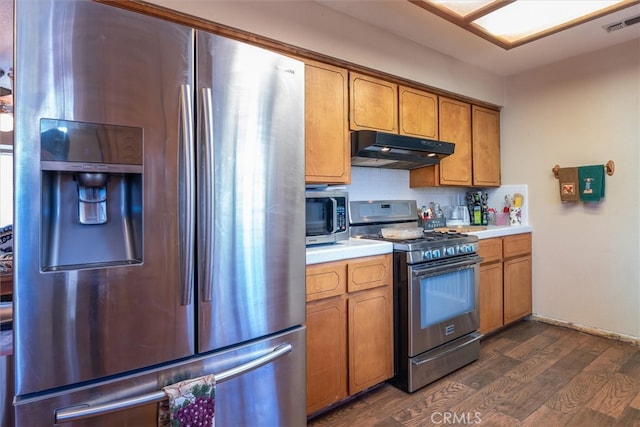 kitchen featuring appliances with stainless steel finishes, decorative backsplash, and dark wood-type flooring