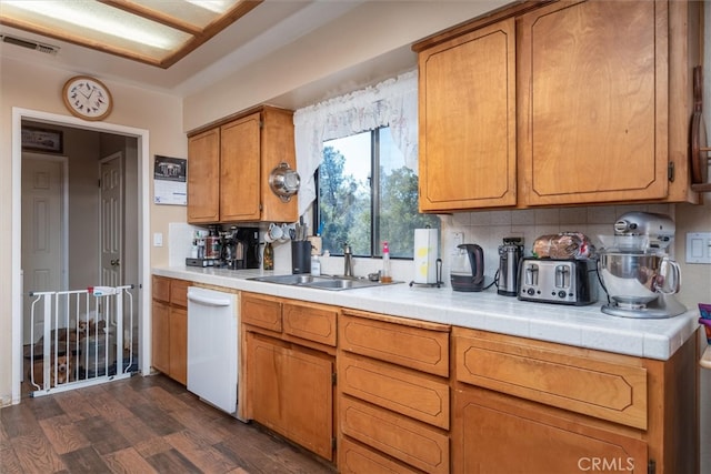 kitchen with decorative backsplash, white dishwasher, sink, and dark hardwood / wood-style floors